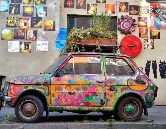 KRAKOW, POLAND - OCTOBER 21, 2012: Old Polish car Fiat 126 placed as a exhibit of local manufacture. Colorful car is part of the gallery, located on the former Jewish district Kazimierz. Nowadays the Cracovian Kazimierz has become the new socializing and artistic centre of the city.