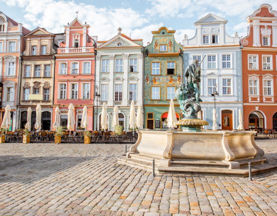 View on the beautiful old buildings with Neptune fountain on the Maket square in Poznan city during the morning light in Poland