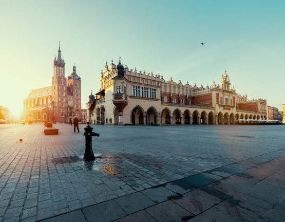 Market square in Krakow at sunrise. Mariacki Cathedral and The Cloth Hall. Poland